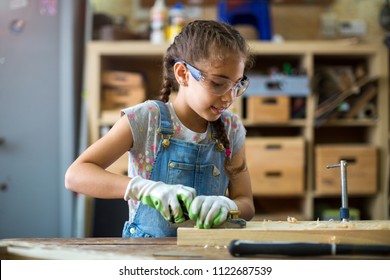 Girl Building Birdhouse In Garage