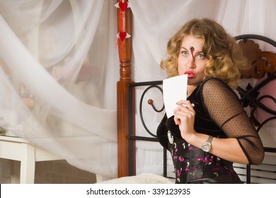 Girl With A Bullet Wound In The Head Sitting On The Bed. Makeup For Halloween 