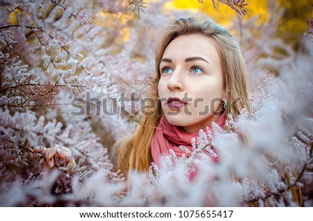 Girl in a bush tamarix. Blooming pink Tamarix. 