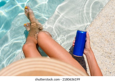 Girl By The Pool With A Can Of Cold Drink On A Summer Day. Top View, Selective Focus On A Can Of Drink.