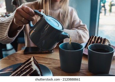 A girl in a cafe pours tea into cups. Beautiful cozy photo. - Powered by Shutterstock