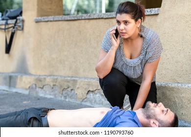 Girl Calling Emergency Service For An Unconscious Guy