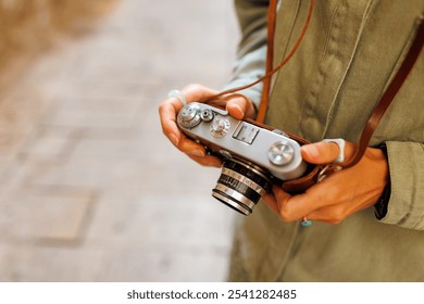 girl with a camera. the photographer adjusts the camera. Stylish girl with a film camera. film camera close up. adventures and travel. - Powered by Shutterstock