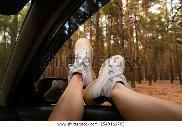 Girl in the car, legs in the window, the location\
in the forest