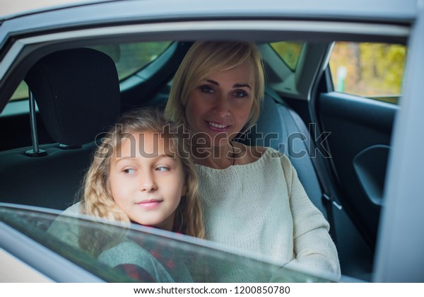  Girl in car with mother, Family traveling\
concept on countryside