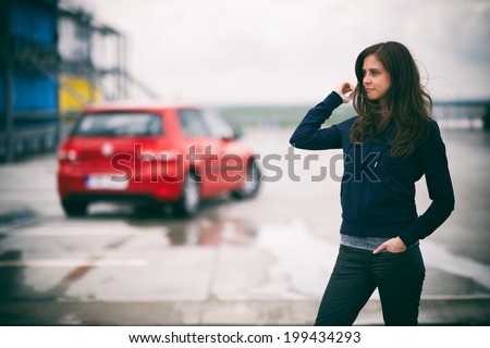 Girl with a car on a parking lot