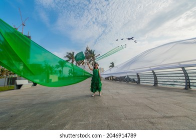 A girl carrying the Saudi flag on the Saudi National Day and the air show - Shutterstock ID 2046914789