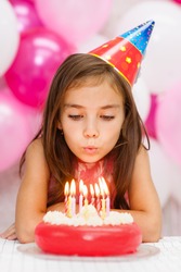 Girl Celebrating His Birthday And Blowing Candles On Cake