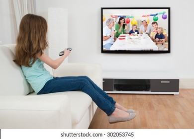 Canal Chica Con Control Remoto Frente A La Televisión En Casa