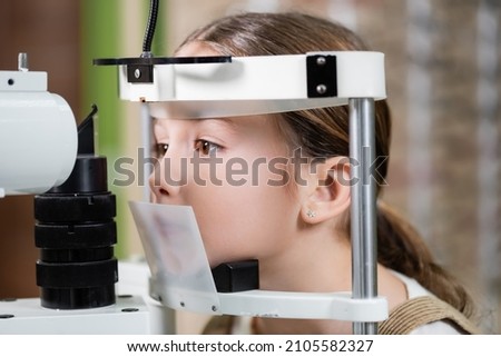 girl checking eyesight on blurred vision screener