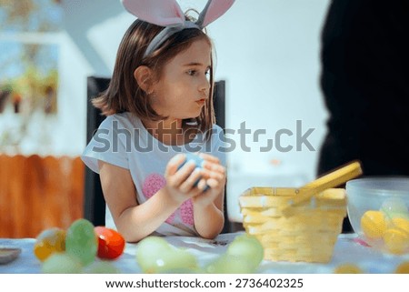 
Girl Checking her Easter Eggs Recovered in a Hunt Celebration
Joyful kid tallying her treasures found in the spring grass 