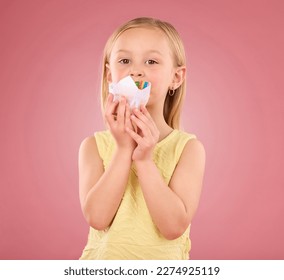 Girl child  cupcake   portrait in studio pink background while eating cake  Face female kid model and sweet snack  creativity   paper in hand isolated color   gradient space