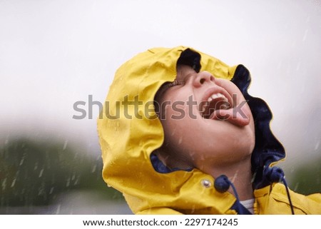 Girl child, headshot and rain for playing, shouting and happiness in nature, outdoor and winter. Female kid, raincoat or playful with water, open mouth or taste on adventure with freedom in childhood