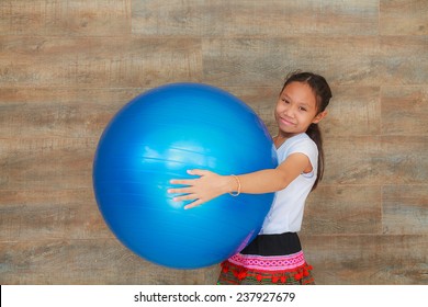 Girl Child Holding Blue Big Rubber Ball.