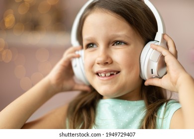 Girl Child Listening To Music With Headphones, Six Years Old 