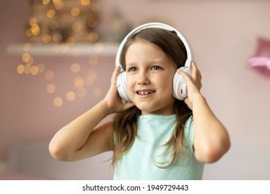 Girl Child Listening To Music With Headphones, Six Years Old 