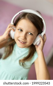 Girl Child Listening To Music With Headphones, Six Years Old 