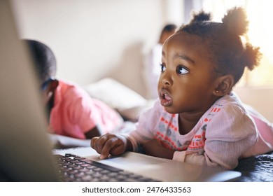 Girl child, online and relax with laptop in home for creative activities, learning and streaming movies. Toddler, internet and technology for curiosity or engaging for education growth or development - Powered by Shutterstock