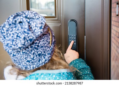 Girl child opening home smart door lock, unlocking the code. Close up view of girl touching pointing the number pad.