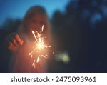 Girl, child and outdoor with sparkler in night for celebration, excitement and glow in dark with entertainment. Female kid, nature and fireworks for magic or party, youth and fun for festive joy.