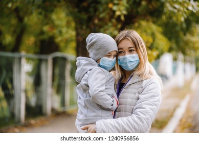 A Girl With A Child Stands On The Road In A Protective Medical Mask. Dense Smog On The Streets. Epidemic Of The Flu