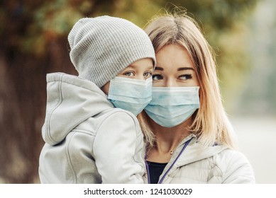 A Girl With A Child Stands On The Road In A Protective Medical Mask. Dense Smog On The Streets. Epidemic Of The Flu