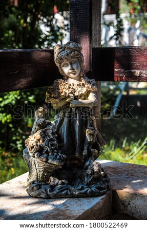 Girl child stone sculpture holding a bouquet of roses.