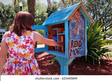 Girl choosing books from a Little Free Library in Florida - Powered by Shutterstock