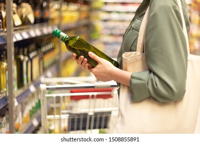 Girl choosing bottle of oil in grocery section of supermarket. Copy space. Healthy diet concept. Sustainable lifestyle - Powered by Shutterstock