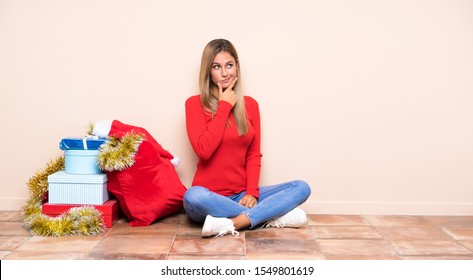 Girl In Christmas Holidays Sitting On The Floor Thinking An Idea