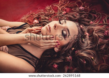 girl with a circlet of flowers on head. charming girl with a flowers. young woman has a beautiful face. girl lying on fur with her long hair