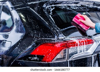 Girl cleaning automobile with sponge at car wash, car washing - Powered by Shutterstock