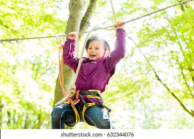 Girl climbing in high rope course enjoying the adventure - Powered by Shutterstock