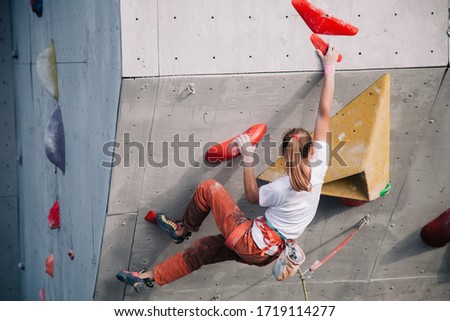 The girl climbs the climbing wall at competitions