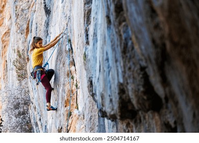  girl climbs a rock. rock climber girl. rock climbing as an Olympic sport. A woman plays sports in nature.
