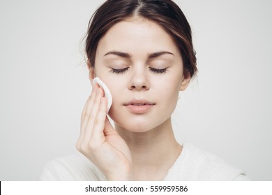 Girl With Closed Eyes And Face Wipes Clean Skin With A Cotton Pad
