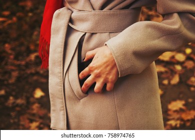 Girl In Coat Puts In Pocket Mobile Phone