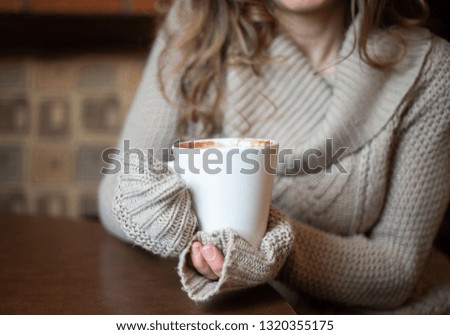 Girl in a coffee shop holding a cup 