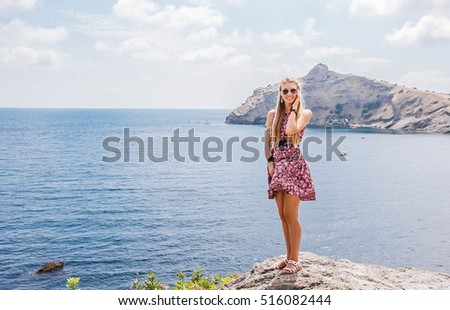 Girl in a colorful dress standing in the background of the amazing Blacksea coast