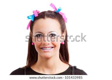 Girl with colorful plaits smiles, isolated on white background. The teenager shows a happy smile and funny expression.