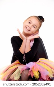 Girl in colorful tutu in the studio with white background during photo shoot. Cute young ballerina inside of the room