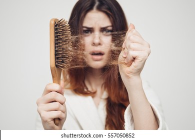 girl with a comb and problem hair on white background