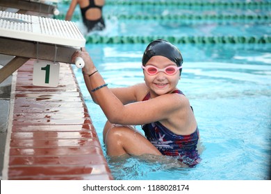 Girl competitive swimmer prepares for backstroke start at the block during a swim meet in swimming pool  - Powered by Shutterstock