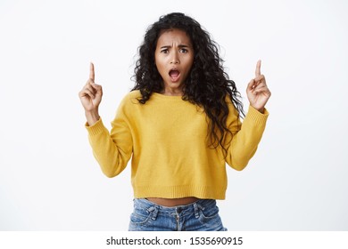 Girl complaining feeling betrayed and upset. Bothered african-american curly-haired woman in yellow sweater looking offended and pissed, gasping from shock open mouth insulted, pointing up - Shutterstock ID 1535690915