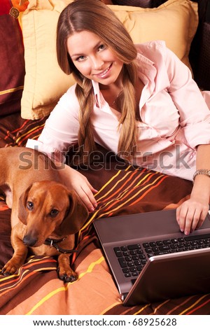 girl and a computer at home and dachshund