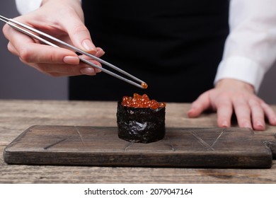 girl cook puts tweezers of salmon on sushi with red caviar close-up. Delicacy, exquisite food, delicious - Shutterstock ID 2079047164