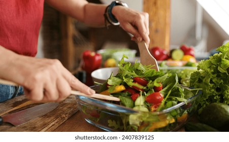 Girl Cooking A Vegetable Salad In The Kitchen Mixing Salad In The Bowl - Powered by Shutterstock