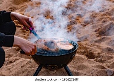 Girl Cooks Sockeye Salmon On The Grill On The Seashore 