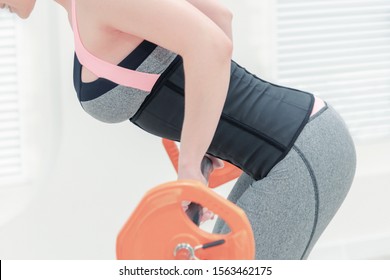 Girl In A Corset And Gray Leggings With A Barbell In The Gym