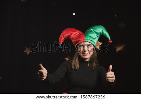 The girl in the costume of the jester grimaces and makes faces